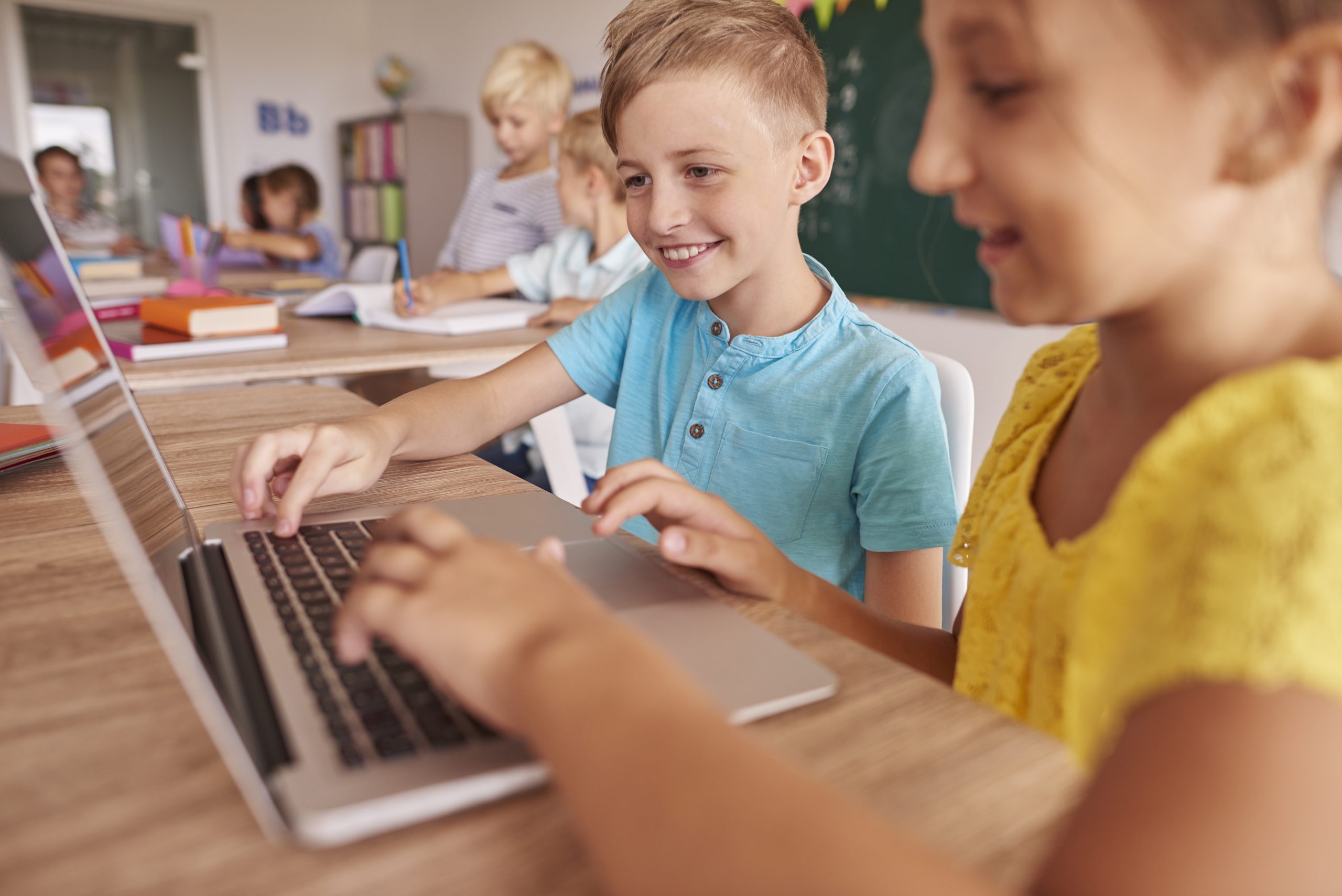 Two kids using laptop during lesson